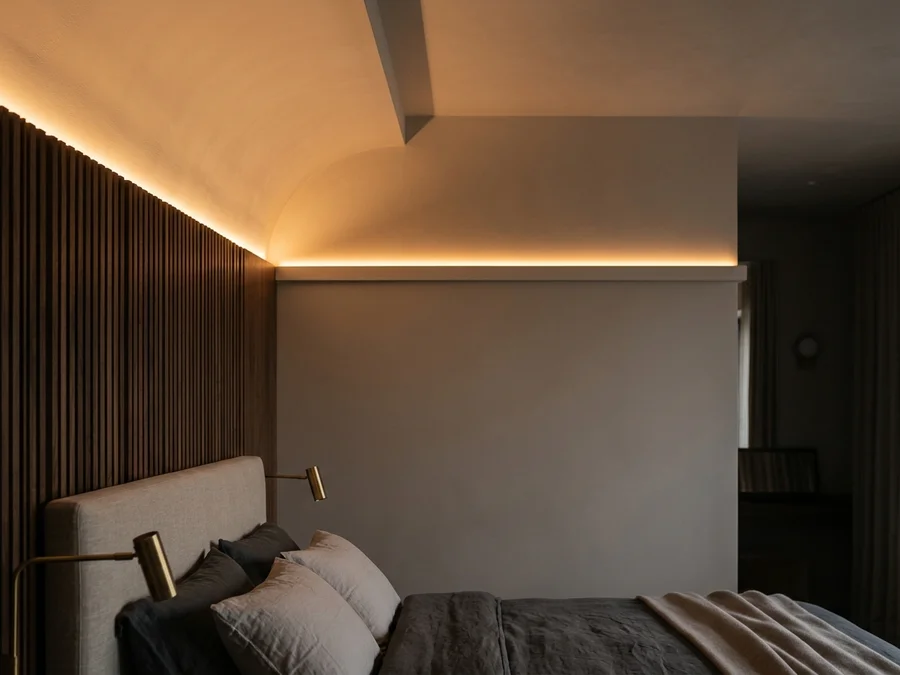 Quarto com sanca de gesso e fita LED indireta de cor amarela suave criando atmosfera de relaxamento
